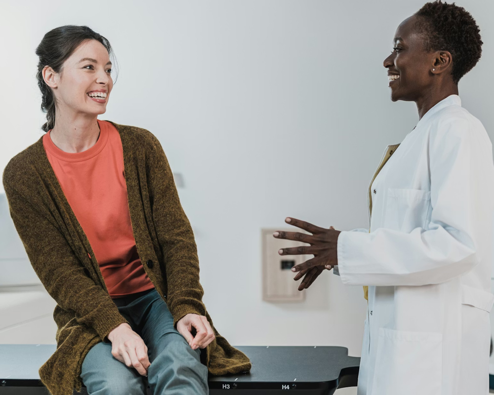 a woman sat on a table talking to a doctor